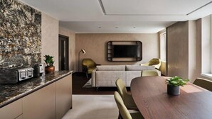 A modern kitchen with a granite countertop, a built-in toaster, and a potted plant. - Sustainably Operated One-Bedroom Apartment in Central London (London)