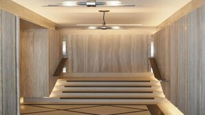 A modern interior with a wooden wall, a staircase, and a ceiling light fixture. - Sustainably Operated One-Bedroom Apartment in Central London (London)