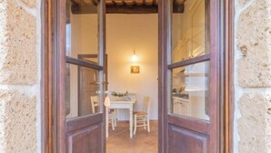 A wooden door leading into a room with a tiled floor, a table, and chairs. - Comfortable and essential for a carefree stay
 (Lazio)