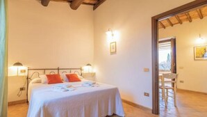 A bedroom with a bed, two bedside lamps, a nightstand, and a chair in a hallway. - Comfortable and essential for a carefree stay
 (Lazio)