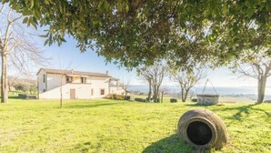 A house with a grassy yard, a tree, and a large tire in the foreground. - Comfort and attention to detail for a stay in the country
 (Lazio)
