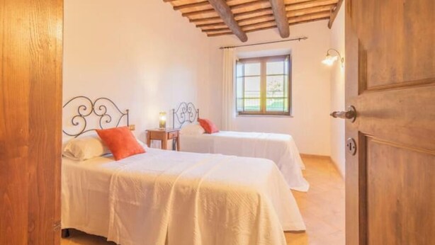 A bedroom with two beds, a window, and a wooden ceiling. - Comfort and attention to detail for a stay in the country
 (Lazio)