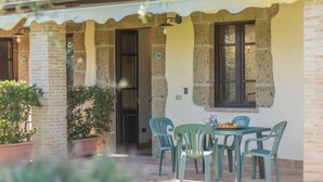 A patio with a table and chairs, surrounded by potted plants and a stone wall. - Comfort and attention to detail for a stay in the country
 (Lazio)