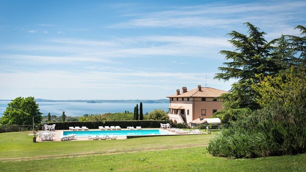 Una casa con piscina, mobiliario de exterior y vistas al mar.