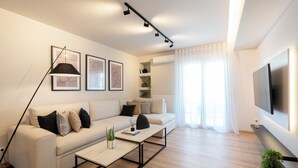 Un salon moderne avec un canapé, une table basse et un téléviseur fixé au mur.