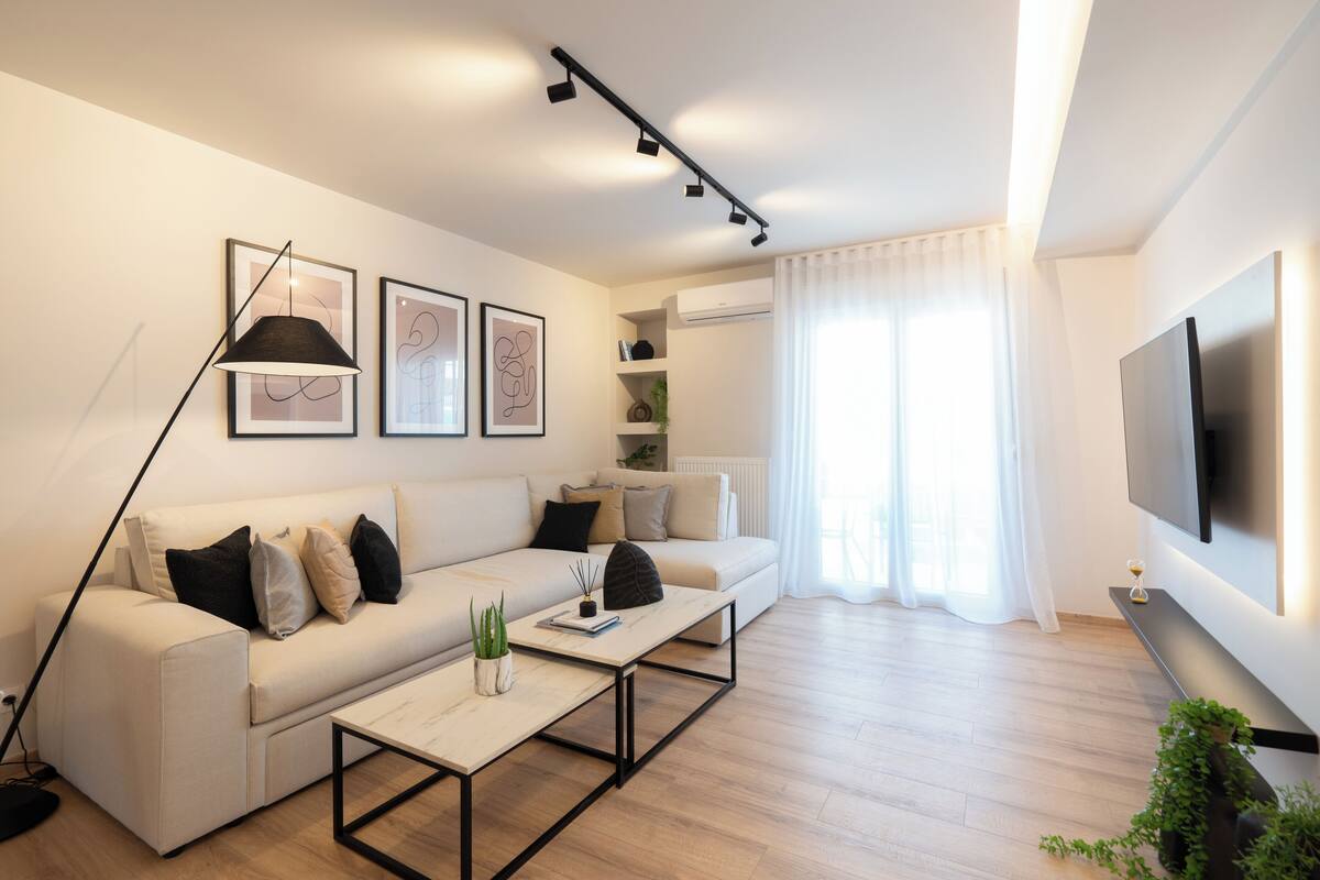 Una sala de estar moderna con un sofá, una mesa de centro y un televisor montado en la pared.