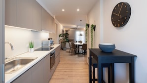 Une cuisine moderne équipée d’un évier, d’une cuisinière et d’un coin repas.