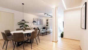 Un salon moderne avec un coin repas, comprenant une table ronde, des chaises, un canapé et une table basse.