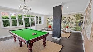 A spacious room with a pool table, large windows, and a tropical mural. - Brisbane Hamilton Hill With Panorama View (Hamilton)