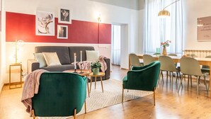 A modern living room with a sofa, chairs, a dining table, and artwork on the walls. - Wine Apartments Florence Prosecco (Firenze)