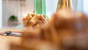 A glass bowl filled with wine corks on a wooden table, with keys and a notebook beside it. - Wine Apartments Florence Prosecco (Firenze)