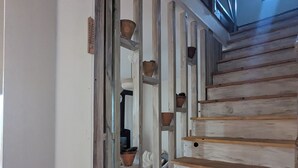 Una scala in legno con pareti bianche e un lucernario.