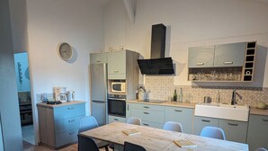Una cucina moderna con tavolo, sedie e forno a microonde integrato.