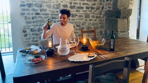 A stone-walled room with a wooden table set for a meal, including plates, glasses, and a bottle. - Step into French history at Le Bastion, Pouzols-Minervois, southern France. (Pouzols-Minervois)
