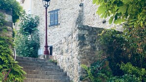 A stone staircase leading to a building with a traditional design, surrounded by lush greenery. - Step into French history at Le Bastion, Pouzols-Minervois, southern France. (Pouzols-Minervois)