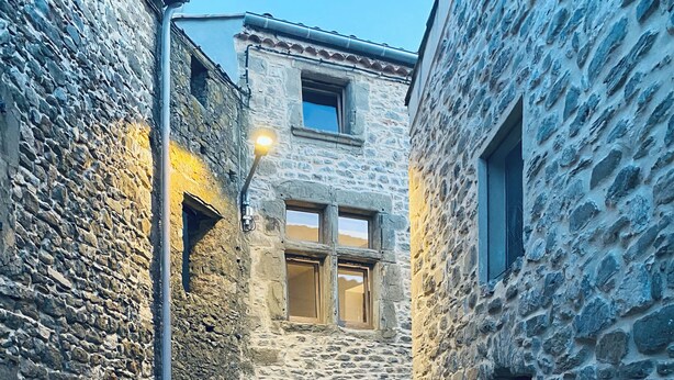A narrow stone alleyway with a central door and windows, flanked by stone buildings. - Step into French history at Le Bastion, Pouzols-Minervois, southern France. (Pouzols-Minervois)