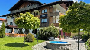 Ein Hotel mit Holzfassade, einem Schild mit der Aufschrift 'TRAIL HOTEL' und einem runden Steinbrunnen im Innenhof.