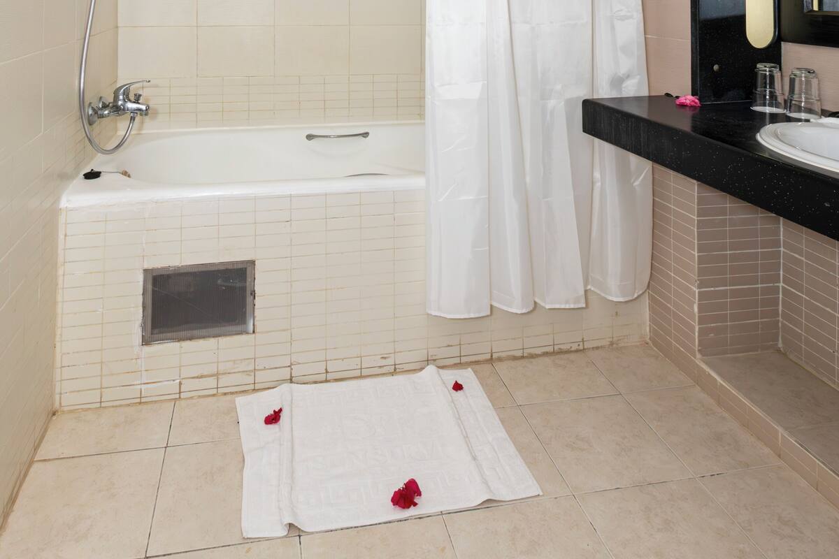 A bathroom with a bathtub, a shower, and a sink.