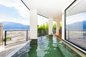 A modern infinity pool with a clear view of the mountains, a glass railing, and a minimalist design. - TERRA Yufuin (Yufu)