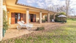 A covered patio with outdoor seating, a brick wall, and a clear sky. - Modern and spacious for an unforgettable stay
 (Lazio)
