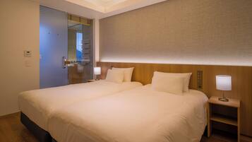 A hotel room with a large bed, bedside tables, and a mirror.