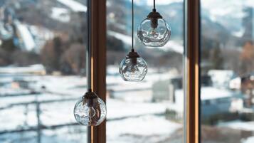 Three hanging glass globes in a window with a snowy landscape view.