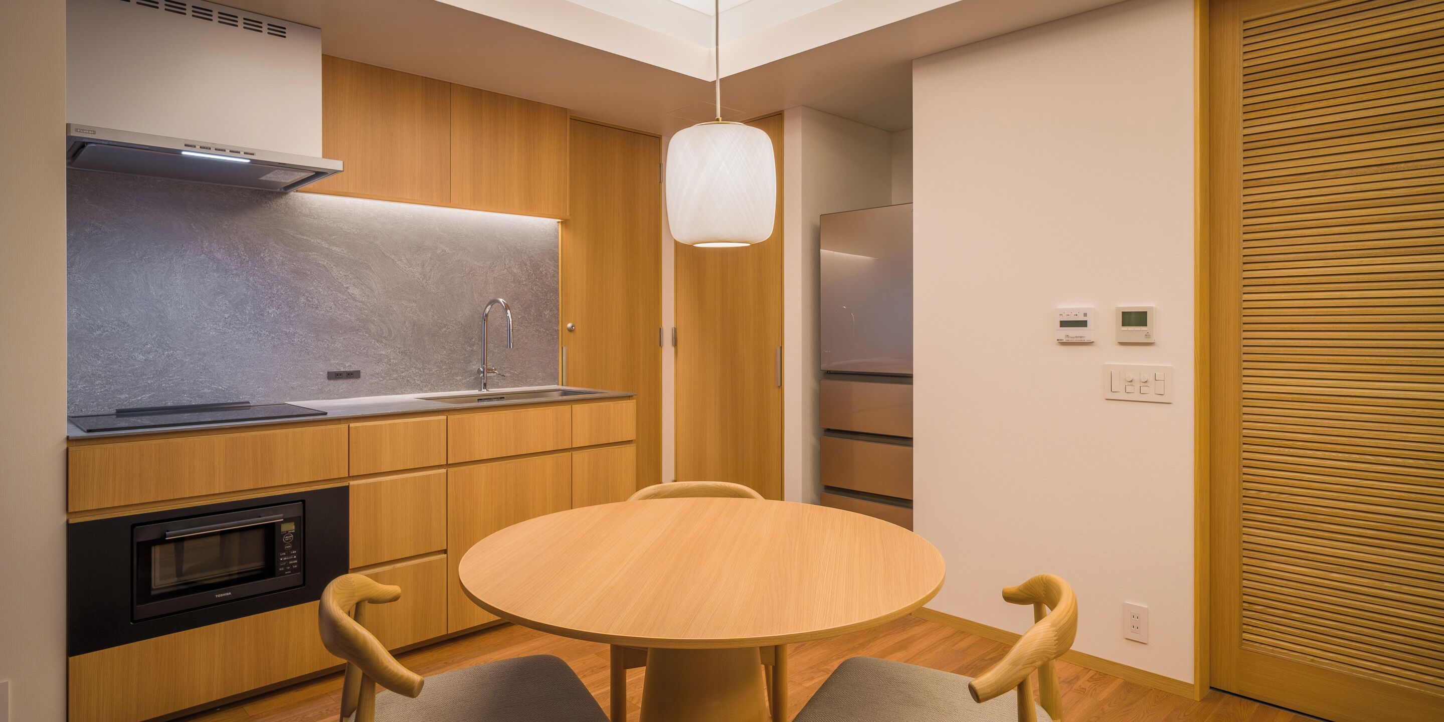 A compact kitchen with a microwave, oven, and modern cabinetry.