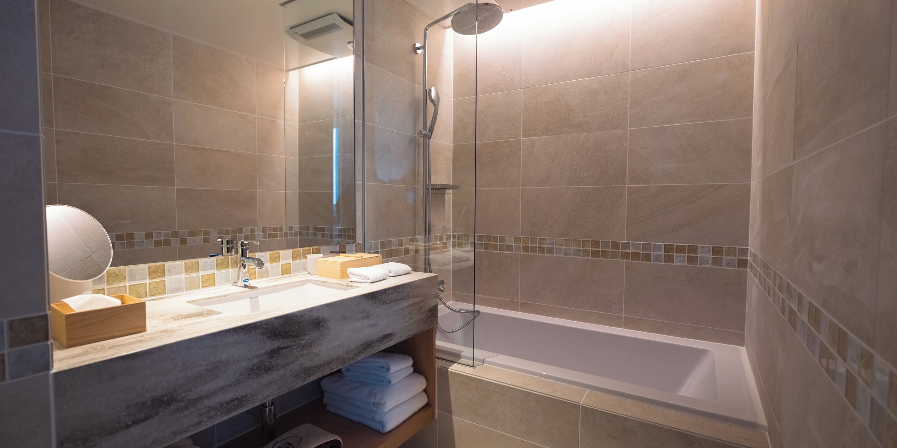 Un bagno moderno con uno specchio grande, due lavabi, una doccia e una vasca da bagno.