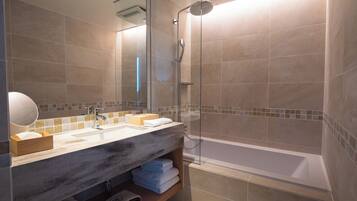 Un bagno moderno con uno specchio grande, due lavabi, una doccia e una vasca da bagno.