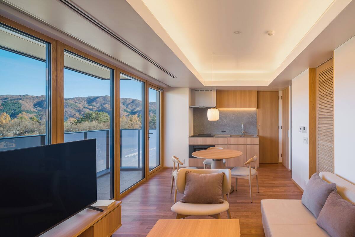 A modern living room with a TV, sofa, and dining area.