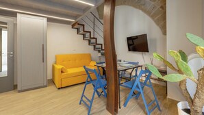 Uma sala de estar moderna com um sofá amarelo, cadeiras azuis, uma mesa de jantar e uma escada.