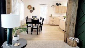 A dining area with a table and chairs, a lamp, and a potted plant.