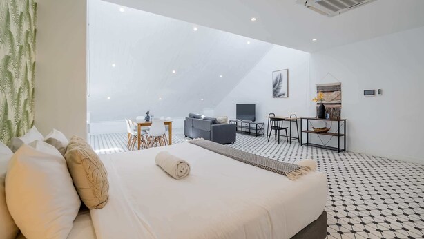 Une chambre d’hôtel moderne, dotée d’un grand lit, d’un bureau et d’un canapé.