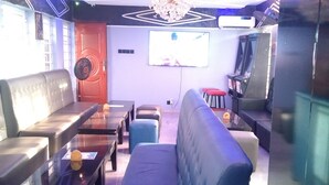 A modern living room with a sofa, a coffee table, and a TV mounted on the wall. - BLUE AO HOtEL (Lagos)