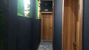 A hallway with dark walls, a wooden door labeled "OAKLAND," and a tiled floor. - BLUE AO HOtEL (Lagos)