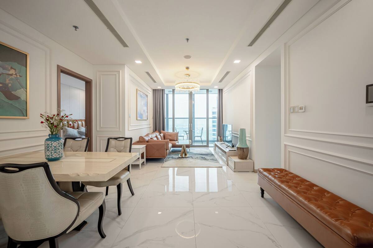 Amplia sala de estar con una gran mesa de comedor, asientos cómodos y vistas al exterior a través de un ventanal.