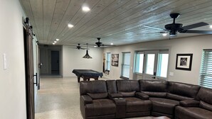 A spacious living room with a sectional sofa, a pool table, and ceiling fans. - Great vacation home for your next adventure. Located in Andrew’s North Carolina. (Andrews)