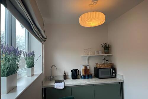 Chambre Deluxe | Cuisine privée | Cafetière-théière, chaise haute, produits de nettoyage écologique