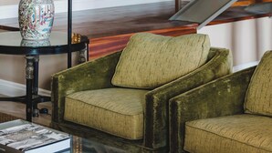 A living room with a green sofa, a glass coffee table, a decorative vase, and a painting on the wall. - Quinta da Carlota (Torres Vedras)