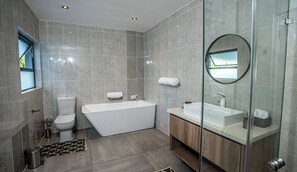 Enjoy a refreshing soak in the bathtub, or rejuvenate in the glass-enclosed shower area.