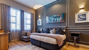 Une chambre moderne avec un grand lit, un bureau et un canapé.