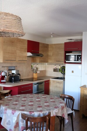 Enjoy meals in this cozy kitchen with a dining table for two, equipped with a range, microwave, and dishwasher.