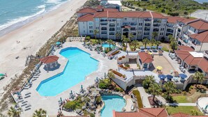 A resort with multiple swimming pools, beachfront views, and a large building with balconies. - Villa Capriani 102B - Oceanfront - Pools - Restaurant - Premiere (North Topsail Beach)