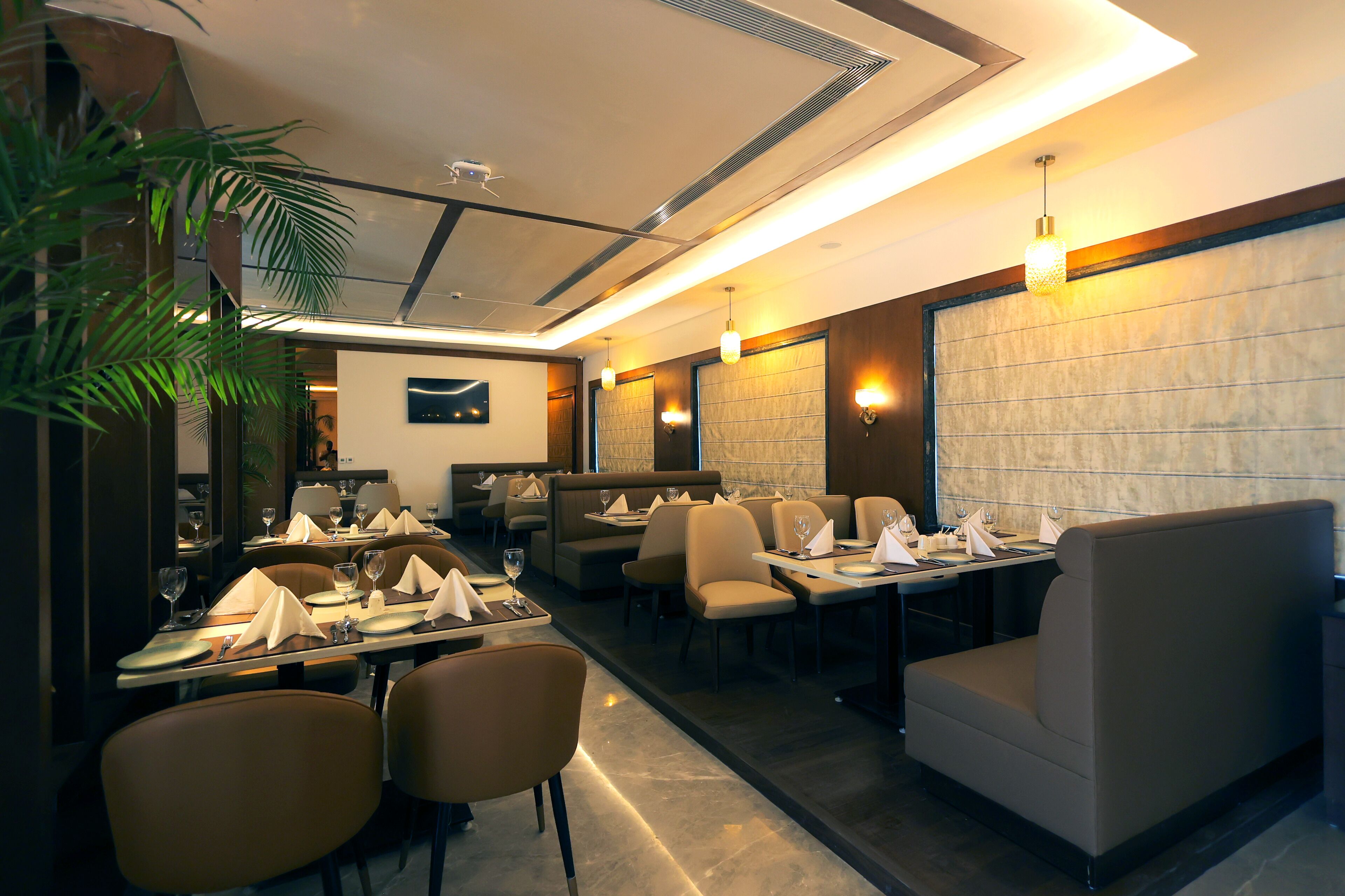 A restaurant with booths and tables, some with napkins and glasses.