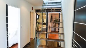 Eine moderne Treppe mit Glastrennstreben und einer schwarzen Tür am unteren Ende.