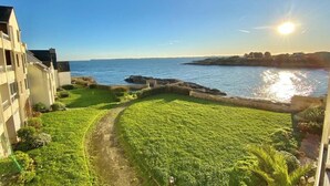 Une propriété située sur la côte, dotée d’une pelouse verdoyante, d’un sentier et d’une vue sur la mer.