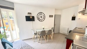 A modern apartment with a dining area, a kitchen, and a living room.