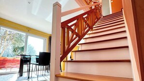A staircase with wooden steps and a wooden railing, leading to an upper floor.