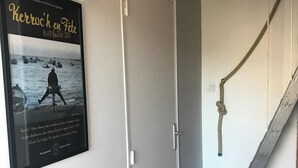 Una habitación con una puerta blanca, un cartel en la pared y un columpio de cuerda.