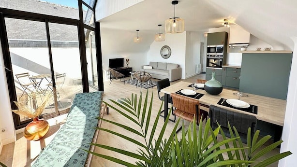 Un appartement moderne de style « loft » comprenant un coin repas, une cuisine et un espace de vie.